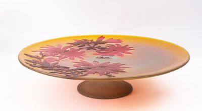 a yellow plate with pink flowers on it on a stand