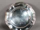 une assiette en argent antique avec un motif décoratif sur le bord