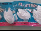 someone is holding a packet of plastic swans in front of a white wall
