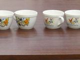 six coffee mugs lined up on a wooden table