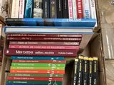 beaucoup de livres dans une boîte posée sur le sol