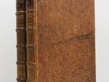 an old book sitting on top of a table next to a white wall
