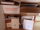 a pile of books on a wooden shelf next to a box