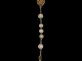 a rosary with a gold cross and pearls on a black background