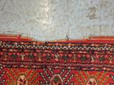 a red rug with a pattern on it on the floor