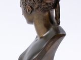 bronze bust of a woman with braids on her hair