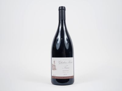 une bouteille de vin rouge posée sur une table blanche