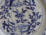 a blue and white plate with birds and flowers on it