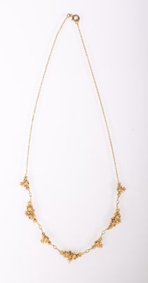 un collier en or orné de petites fleurs sur une chaîne