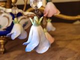 a chandelier that has a bunch of flowers hanging from it