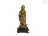une image représentant une statue de moine posée sur un socle en bois