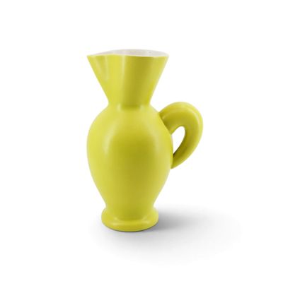 un vase jaune posé sur une surface blanche