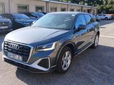 L'Audi QX est garée sur un parking, avec d'autres voitures en arrière-plan.