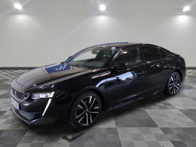 la voiture noire est garée sur un sol en damier dans le garage