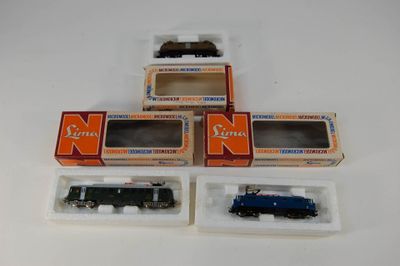 trois trains miniatures dans leurs boîtes, empilés les uns sur les autres