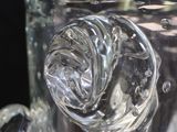 a glass vase filled with water and ice on a table