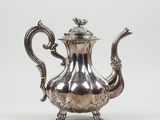 an antique silver teapot with ornate decoration on a white background