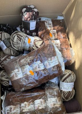 many balls of yarn in a box of brown and white yarn