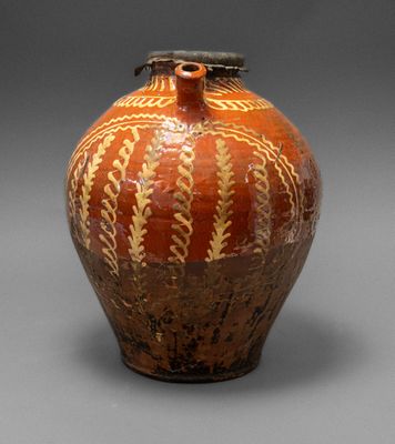 un vase marron posé sur une surface grise