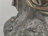 a bronze statue of a woman reading a book
