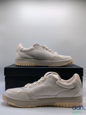 a pair of white sneakers sitting on top of a black box