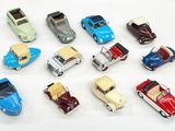 beaucoup de petites voitures miniatures posées sur une surface blanche