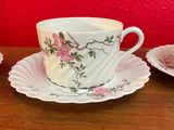 three cups and saucers sitting on a wooden table