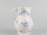 a white and blue vase with blue flowers on it