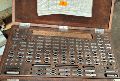 un vieux coffret en bois contenant de nombreuses pièces métalliques