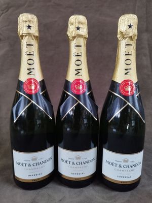 trois bouteilles de champagne Moët posées sur une table
