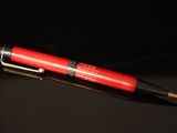 a red pen sitting on top of a black table