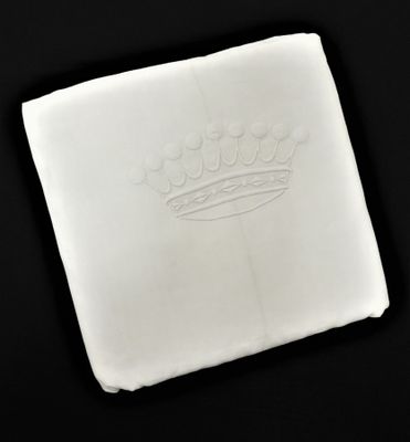 une photo d'une serviette blanche sur laquelle figure une couronne