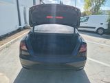 a black car with its trunk open in a parking lot