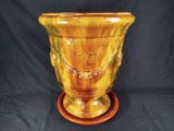 a yellow vase that is sitting on a wooden stand