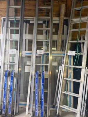 de nombreuses échelles appuyées contre le mur d'un immeuble