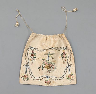 un sac blanc orné d'un motif floral et de perles qui y sont suspendues