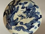 une assiette bleue et blanche ornée d'un motif représentant un dragon