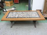 a coffee table with a mosaic top on a green floor