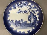 a blue and white plate with a picture of a man on a horse drawn carriage