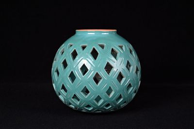 un vase vert orné d'un motif en treillis