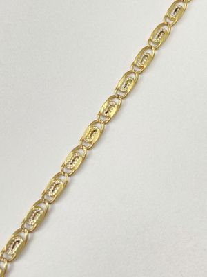 a close up of a gold chain bracelet on a white background