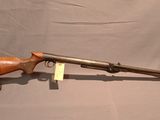 an old rifle with a wooden barrel on a stand