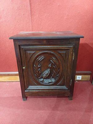 une vieille armoire en bois sur laquelle est sculpté un oiseau