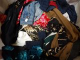 a pile of clothes sitting on top of a bed