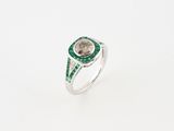 a close up of a ring with a green stone in the center
