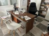 a desk with two chairs and a computer on it