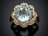 a close up of a ring with a blue topaz stone surrounded by diamonds