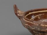 a brown and white bowl with a fish design on it