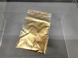 un sachet en papier doré exposé dans une vitrine en verre