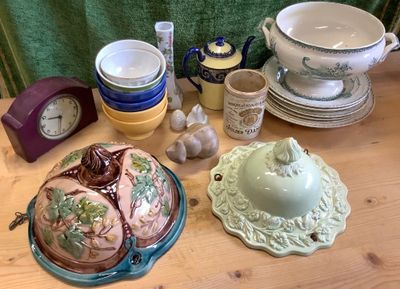 une table en bois sur laquelle sont posés des assiettes, des bols et une horloge